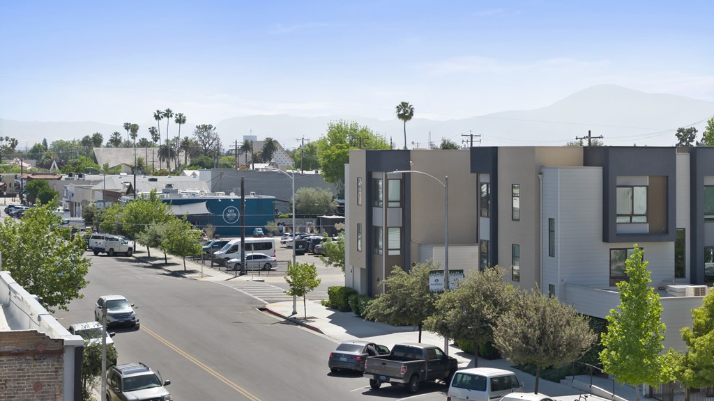 A street view of a residential area with cars parked on the side of the road.